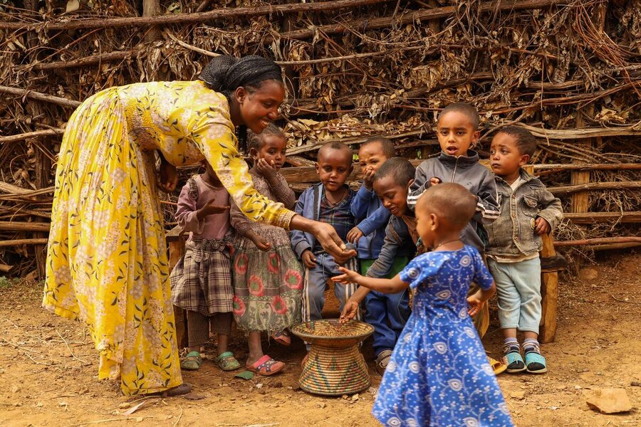 Tadel Gebeyehu, served kids with roasted wheat  after receiving food assistance in Beyeda, Amhara region of Ethiopia.