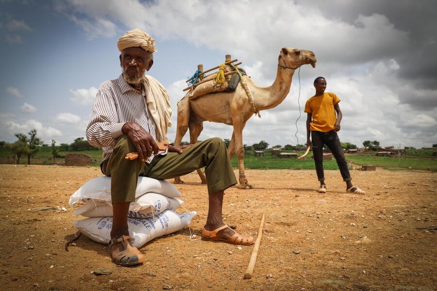 Man sits on WFP food bags in Tigray Michael Tewelde