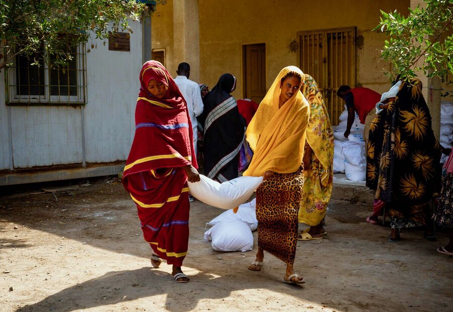 Women receive WFP food distributions at a school in Port Sudan, a city where thousands of displaced people are sheltering. Photo: WFP/Abubakar Garelnabei