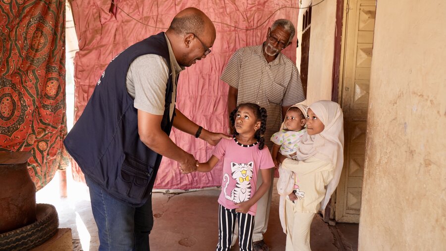 WFP Emergency Coordinator Karim Abdelmoneim greets young children. Like many Sudanese, he's been displaced by the conflict. Photo: WFP/Abubakar Garelnabei
