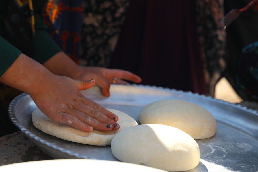 An Afghan refugee makes bread in Iran
