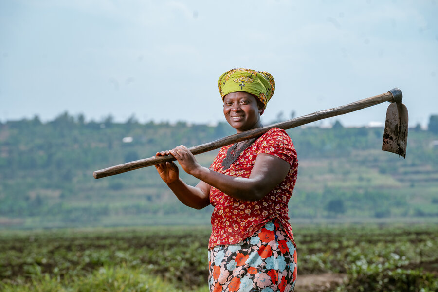 landine Mukakarisa poses for a photo with a hoe, a tool she uses to cultivate the garden. Her maize production increased due to good agriculture practices. Photo: Cordaid/Irihose Mugiraneza