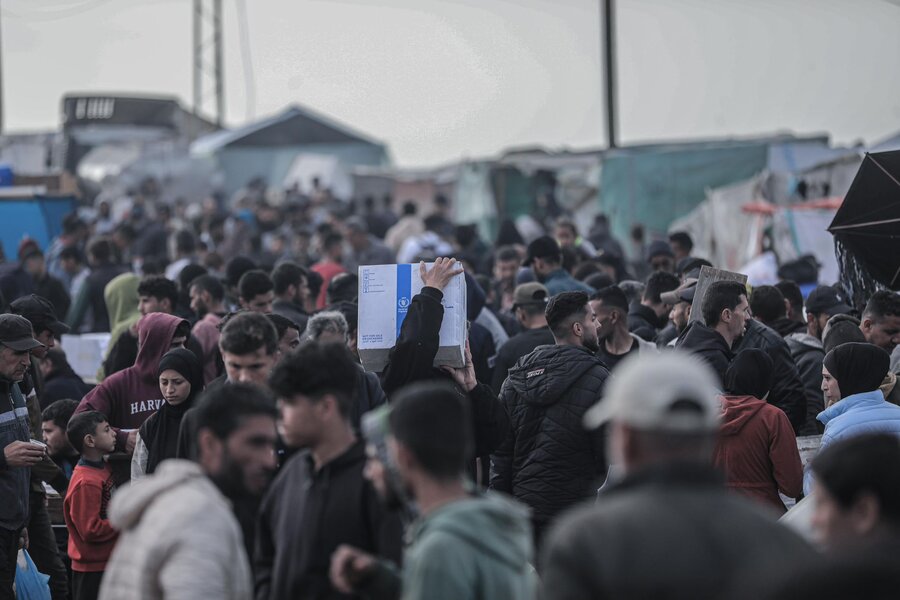 WFP food box is carried among a crown in Gaza