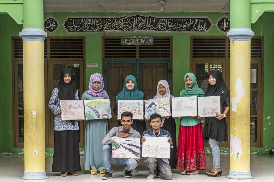 School girls displaying artworks created in the wake of the tsunami