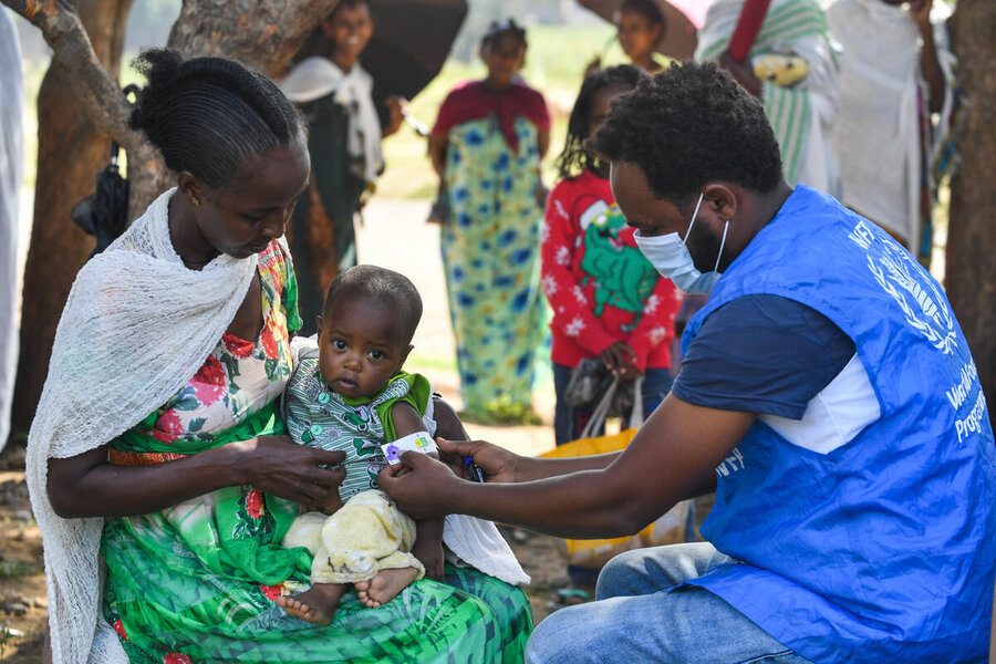 A WFP worker checks a child for malnutrition at a displacement camp in Ethiopia's Tigray region. We may be forced to deeply cut assistance for millions of people in the country. Photo: WFP/Michael Tewelde