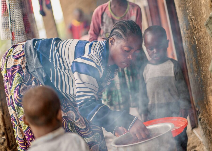 Displaced farmer Bernadette cooks dinner for her children with WFP food. Photo: WFP/Benjamin Anguandia