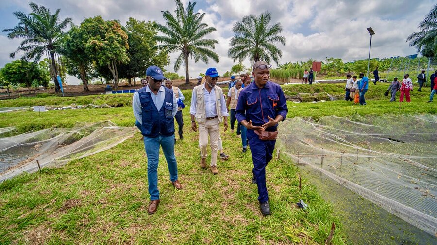 WFP's Eric Perdison (L) tours Ignye, on the outskirts of DRC's capital, Kinshasa, where WFP is investing in a raft of projects, from literacy and skills training to sustainable farming - showing the dividends of peace. Photo: WFP/Michael Castofas