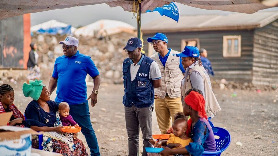 WFP Eastern and Southern Africa Regional Director Eric Perdison (in dark blue cap and vest) chats with a woman receiving our assistance in the eastern Congolese town of Goma. Photo: WFP/Michael Castofas