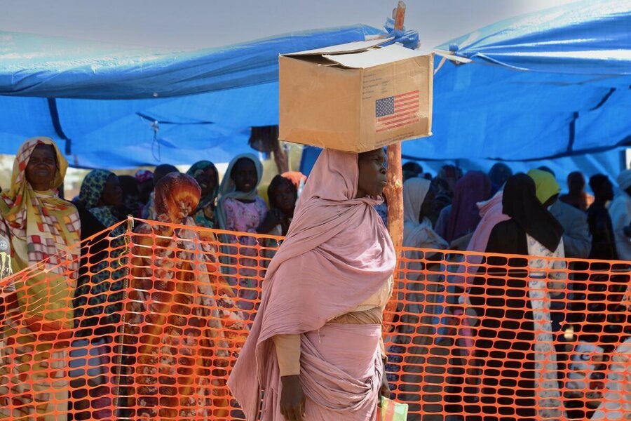 A refugee woman carries a box of US-funded food assistance following a WFP food distribution in Chad - where nearly three million people are expected to face severe hunger. Photo: WFP/Asma Achahboun
