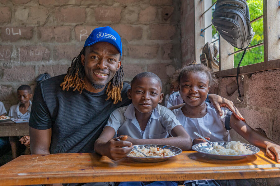 Congolese football star and WFP High-Level Supporter Distel Zola chats with kids enjoying our school meals in the Democratic Republic of the Congo. He counts among the many people lending their voices to fight hunger. Photo: WFP/Michel Castofas