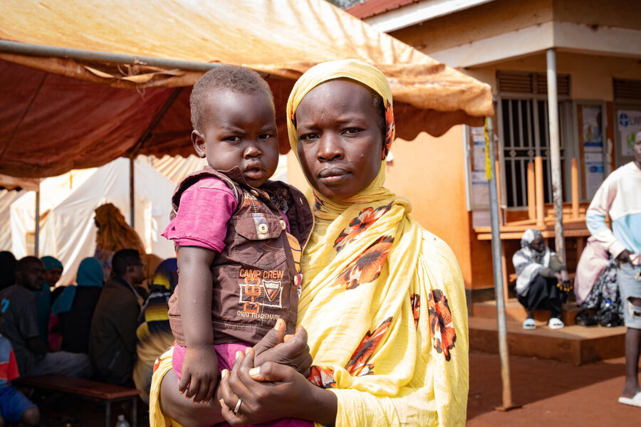 Omnia with her young son in her arms at Uganda's Kiryandongo refugee settlement, after arriving from neighbouring Sudan. Photo: WFP/Daisy Masembe