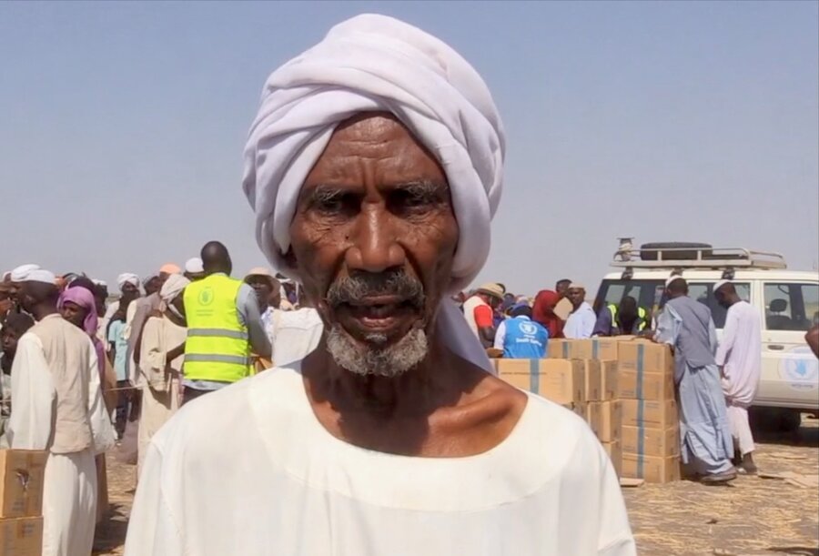 Sudanese refugee Abdullah stands in front of boxes of WFP food at Renk transit centre in South Sudan. Photo: WFP/Peter Louis