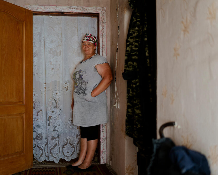 Woman stands in a doorway of her home in Ukraine