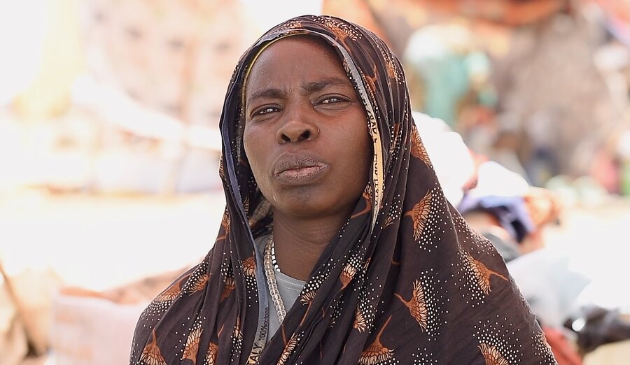 A woman in a brown patterned headscarf stares into the camera. Photo: WFP/Mohamed Galal