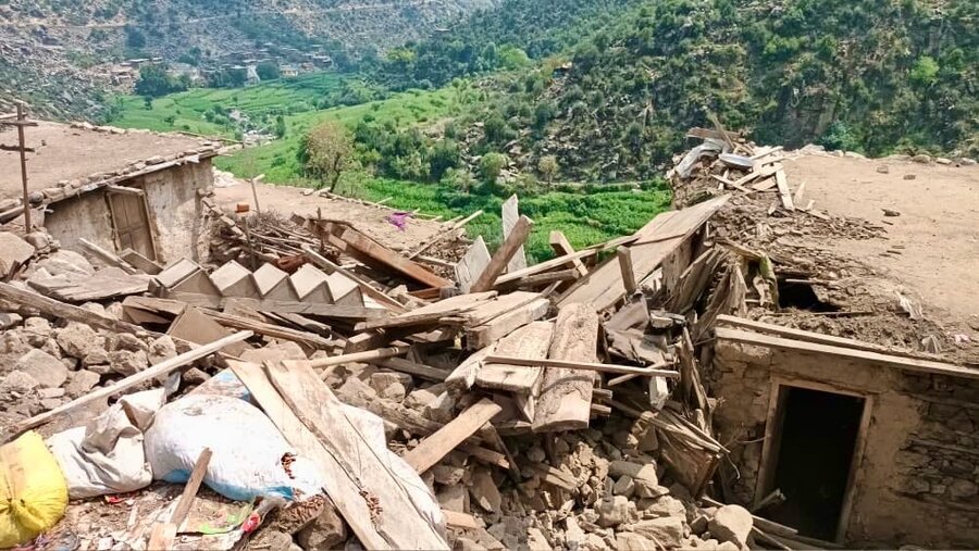 The rubble of a quake-damaged stone house, flanked by trees and mountains in eastern Afghanistan's Kunar Province. Photo: WFP/Aslam Haiderzai