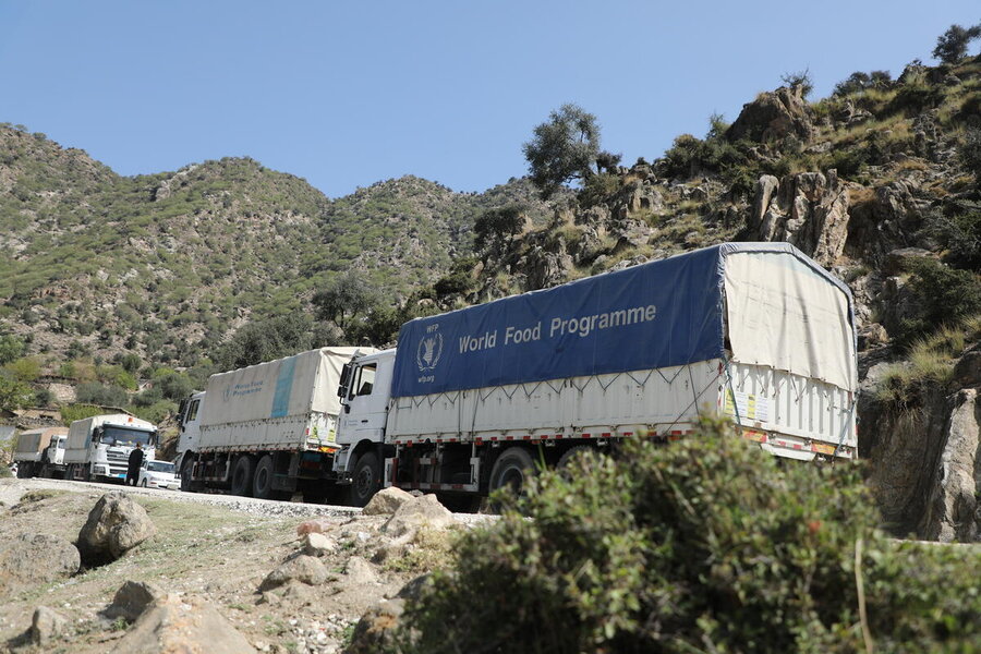 A line up trucks with WFP's blue logo navigate a mountain pass in Afghanistan. Photo: WFP/Arete/Muktar Nikrawa