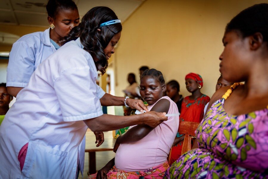 At a crowded health clinic, a nurse checks a pregnant women for malnutrition. Photo: WFP/Charly Kasareka