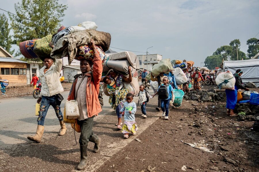 Conflct-displaced people, carrying their belongings on their heads, walk down a dirt path in northeastern DRC. Photo: WFP/Moses Sawasawa