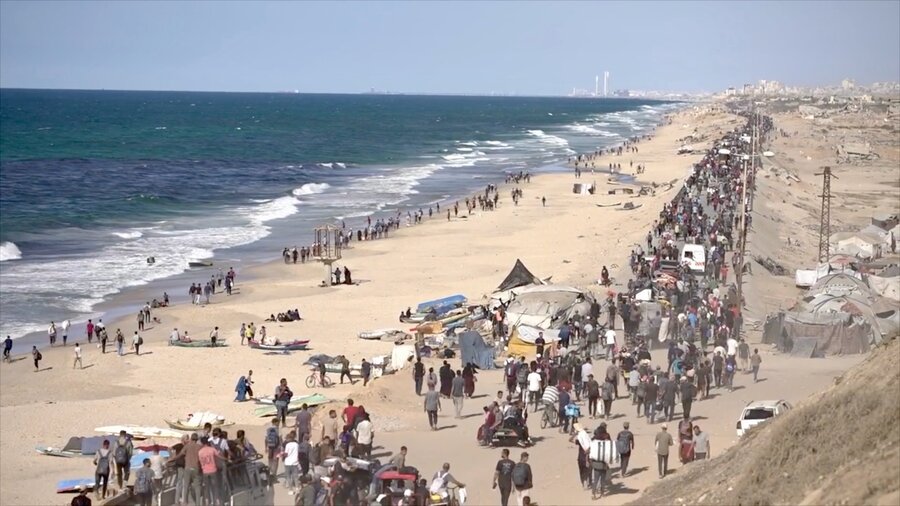 An aerial view of thousands of people on the move in Gaza, carrying their belongings, abutting a strip of coastline. Photo: WFP