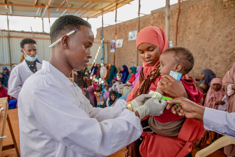 A health worker checks a little baby (held by his mother) in Jubaland, Somalia. Photo: WFP/Arete/Mahad Said