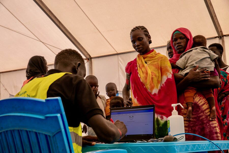 Women and their children arriving from Sudan line up for registration in a tent at South Sudan's Renk Border crossing. Photo: WFP/Eulalia Berlanga