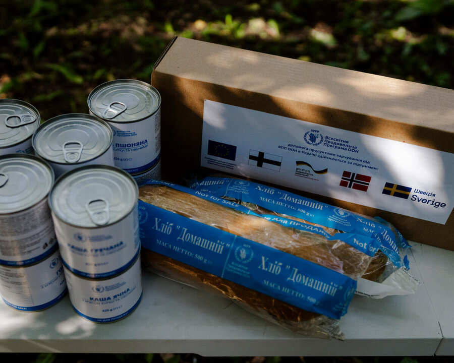 Tins, bread and a small cardboard box of food branded with WFP logo