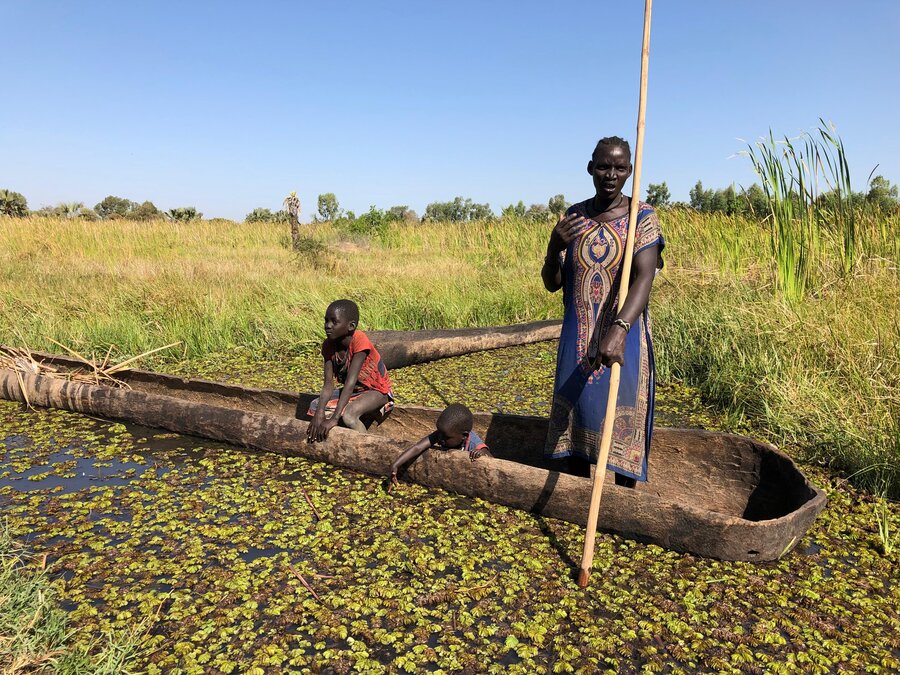 A woman and boy paddle a wooden canoe through a swampy slice of South Sudan. Photo: WFP/Jonathan Dumont