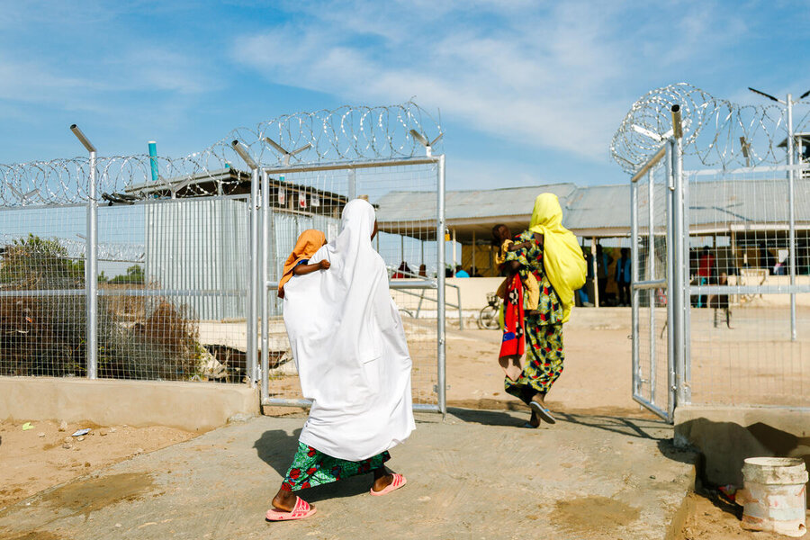 Women in long gowns and scarves arrive at a WFP-supported health clinic in Dikwa, Nigeria that is ringed with barbed wire for protection. Photo: WFP/Nommiyid Chantu
