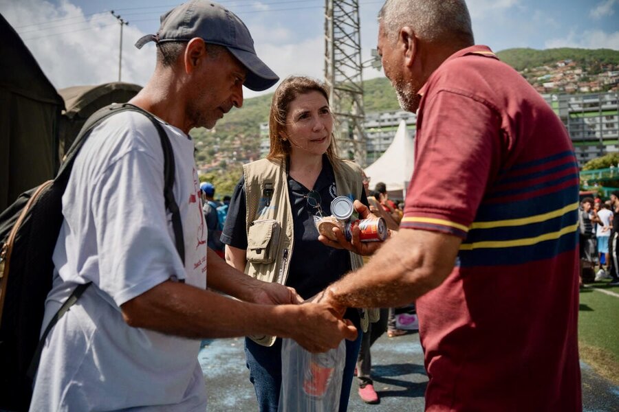 A woman in a tan WFP vest speaks to two men in earthquake-hit La Guaira, Venezuela. Photo: WFP/Gustavo Vera