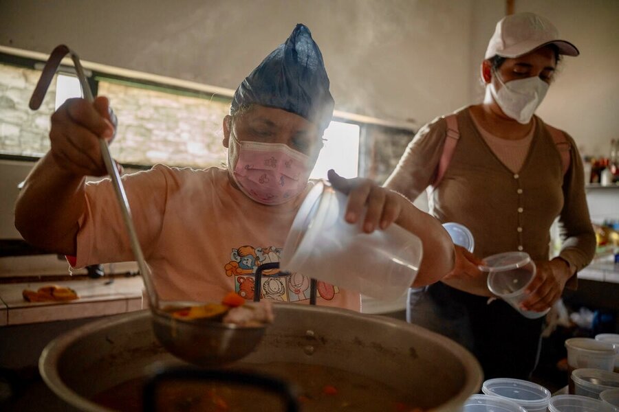 A women ladles food from a large pot into plastic containers. Photo: WFP/Gustavo Vera
