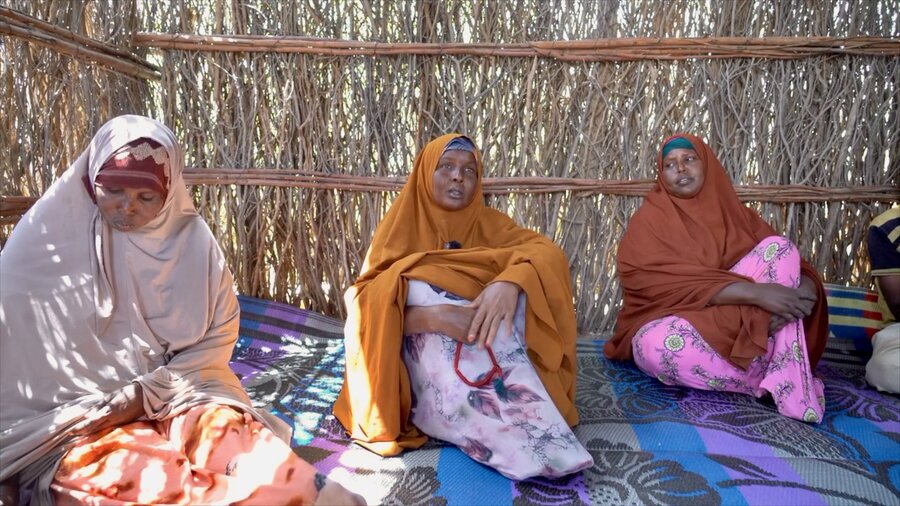 Three women in long gowns sit on a carpet in a thatched hut in Somalia. Photo: WFP/Sylvie Njobati 