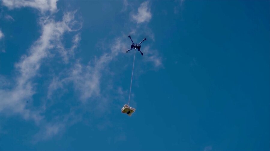 A drone carrying WFP cargo flies across a blue sky. Photo: WFP