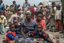 Photo by WFP/Michael Castofas. A mother with her children displaced by violence wait to register with SCOPE to receive the first assistance. She has lived in the Rusayo camp, close to Goma  since November 2023. 