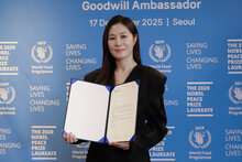 Photo: WFP/Korea. Moon So-ri, WFP Goodwill Ambassador, smiles while holding the ED Cindy McCain's Welcome Letter. 