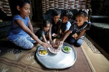 Photo: WFP/Anas ElBaba, children gathering  over the traditional Gazan Rummaniyah dish. Using electronic food vouchers, WFP with the generous support of Japan helps tens of thousands of the poorest Palestinian families purchase nutritious food from local shops. 