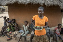 Photo: WFP/Matteo Cosorich, woman holding a plate of cicadas which the family eats when WFP food has run out. 