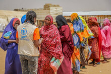 Photo: WFP/Arete/Salamon Djek: Sudanese refugees queue for food aid distribution after having taken a biometric test to confirm their identity in Adré, Ouaddai, Chad