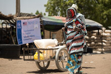 Yakura Usman, 70, receives food assistance at a distribution centre from where WFP provides life saving relief, including in-kind food rations, electronic food vouchers, and specialized nutrition support for vulnerable households and internally displaced persons in Dikwa, Borno State, Nigeria.