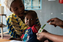 WFP/Arete/Fredrik Lerneryd. WFP staff, Francis Mpoyi, measures baby's arm during a routine check-up in Kalemie, Democratic Republic of Congo on 19th February 2021.