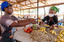 WFP/Andy Higgins. Zambia. Mulumbwa, a refugee from DRC, serves a customer at her market stall