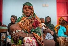 photo: WFP/Abubakar Garelnabei, child sleeping in her mother's hands while waiting for her turn to get the measurements taking in the WFP-supported heath center in Port Sudan.  