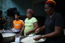 WFP/Oscar Duarte, women cooking free meals for the children of the community named Guililandia, who were affected by the Hurricane. Part of the rice she has served to the children was WFP rice.