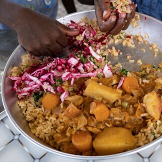 Aerial photo of hands mixing a bowl of food.