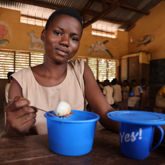 A young girl benefiting school meal from a WFP-led school feeding project at a local primary school.