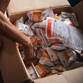 A health worker takes rations of nutrient-rich Plumpynut to distribute them to children in DR Congo