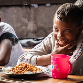 Kamwanya Noëlla (11 years old) receives her school meal provided by WFP as part of the school feeding programme in DR Congo.
