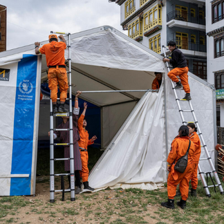 Emergency response personnel put up a WFP tent in an urban area, strengthening preparedness and rapid response to disasters and crises.