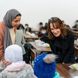 Two women talking to schoolchildren in classroom