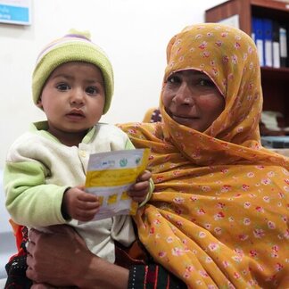 Mother holding a child who is carrying nutrition supplement