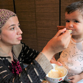 a mom is feeding her child